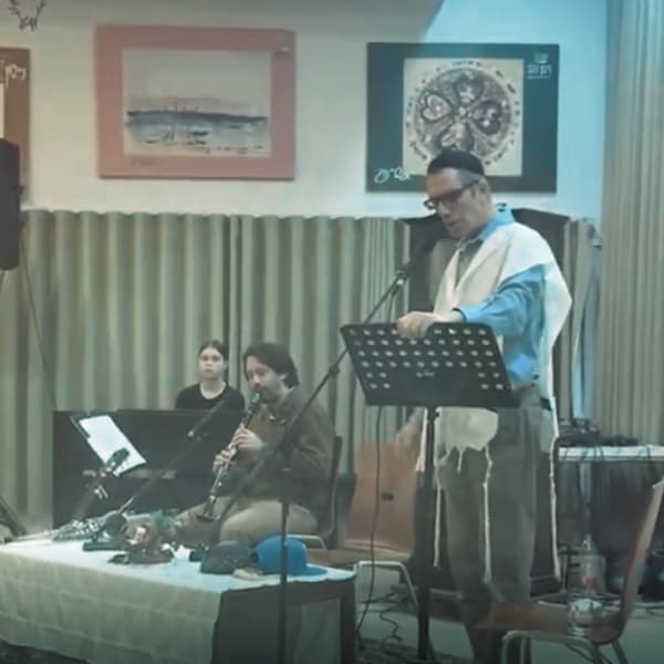 ראובן מודק מופיע על הבמה עם קלרינט במופע המהפחה הכסידית